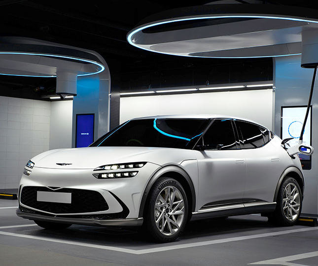 A white SUV electric car charging at a station. 